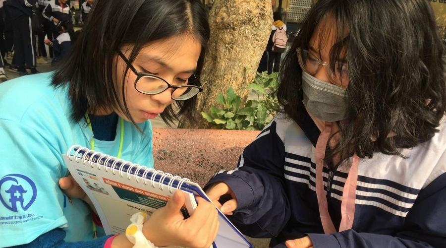 A couple of girls reading a notebook